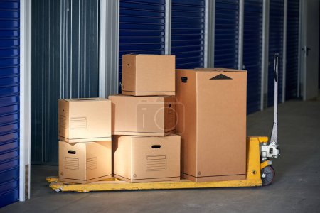 Foto de Almacenamiento en un edificio industrial para alquiler a empresarios o particulares con cajas de cartón reciclables en la parte superior de una estantería de palets. - Imagen libre de derechos