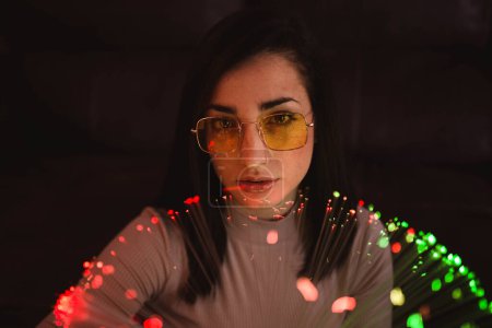 Foto de Mujer joven con luces de hadas en la oscuridad - Imagen libre de derechos