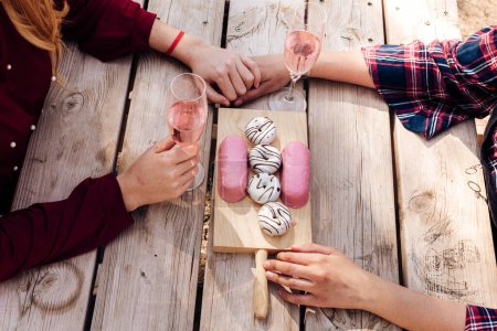 Photo for Hands of women with wineglasses at picnic table - Royalty Free Image