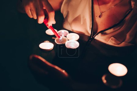 Téléchargez les photos : Cultiver personne allumant des bougies dans la piscine - en image libre de droit