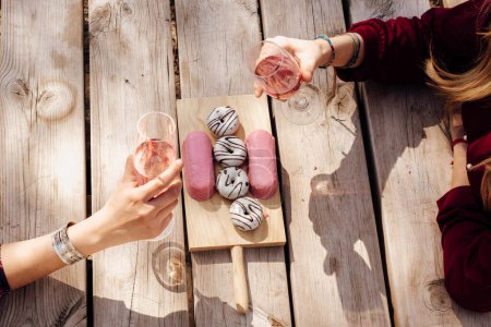 Photo for Hands of women with wineglasses at picnic table - Royalty Free Image