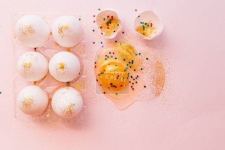 Photo for From above broken Happy Easter egg decorated with sparkles and colorful stars on pink background - Royalty Free Image