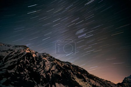 Photo for Low angle on snowy mountain peak against breathtaking starry sky at night in countryside - Royalty Free Image