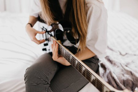 Téléchargez les photos : Jeune femme brune jouant de la guitare - en image libre de droit