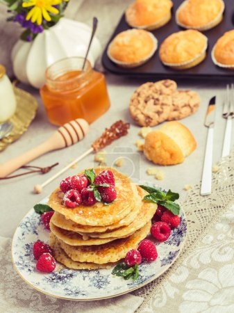 Photo for High angle of pile of appetizing pancakes garnished with ripe raspberries and served on plate on table for breakfast - Royalty Free Image
