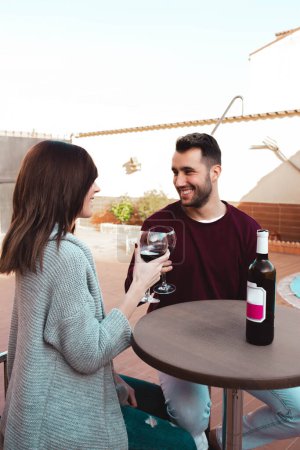 Photo for Happy couple drinking wine on terrace - Royalty Free Image