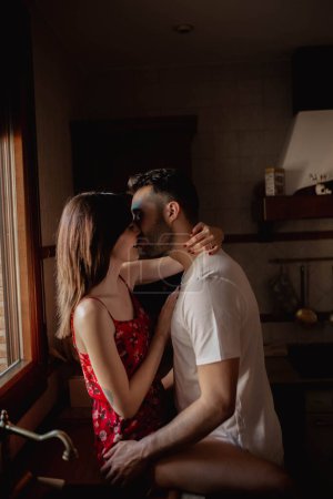 Téléchargez les photos : Heureux couple baisers dans cuisine - en image libre de droit