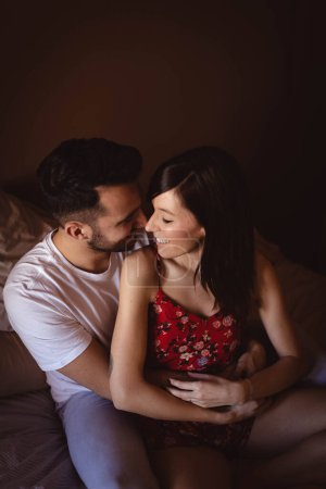 Photo for Happy couple sitting on bed - Royalty Free Image