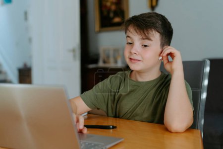 Photo for Focused kid using laptop at home - Royalty Free Image