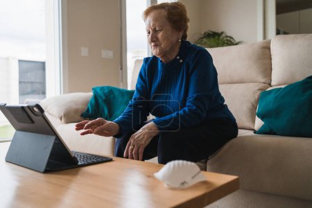 Foto de Vieja mujer comunicarse con su hija en el chat de vídeo en el ordenador portátil - Imagen libre de derechos
