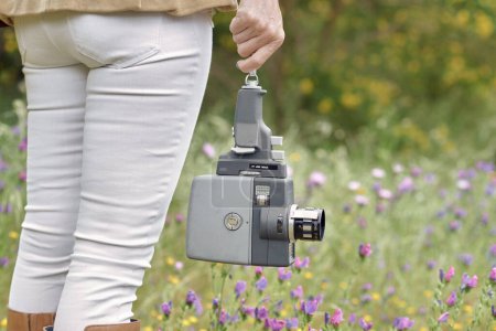 Photo for Crop photographer walking in park with vintage video camera - Royalty Free Image