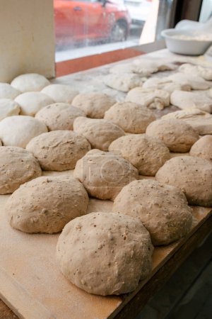 Photo for Portrait of several loaf-shaped bread doughs on a table in a bakery ready to bake in the oven - Royalty Free Image