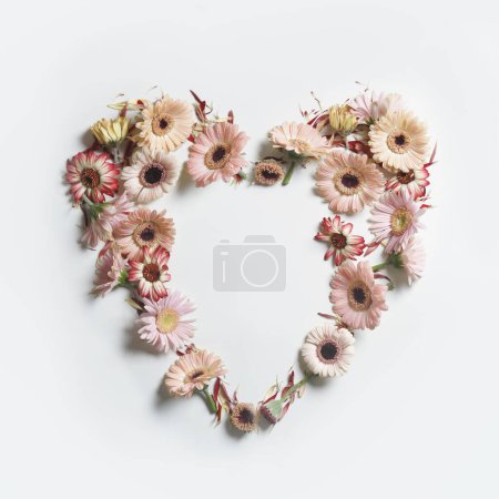 Photo for Heart frame made with various garden flowers at white background. Romantic concept with spring and summer petals for Valentine or Mother day. Top view. - Royalty Free Image