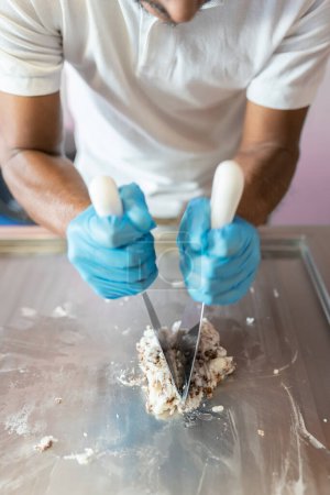 Téléchargez les photos : Un travailleur utilise des spatules pour préparer un rouleau sur une machine à crème glacée roulée. Concept de nouvelle petite entreprise - en image libre de droit