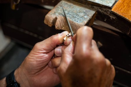 Téléchargez les photos : Goldsmith travailler et créer dans son travail de bijoux en or d'artisanat - en image libre de droit