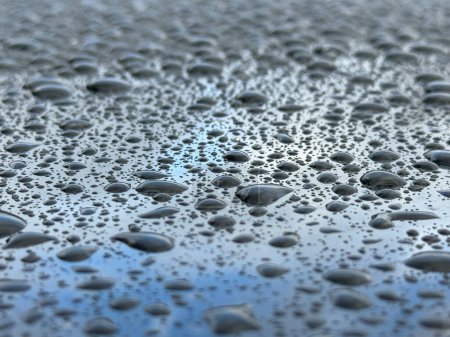 Photo for A wet surface with many small drops of water scattered across it. Scene is calm and serene, as the drops of water seem to be falling gently and evenly across the surface - Royalty Free Image