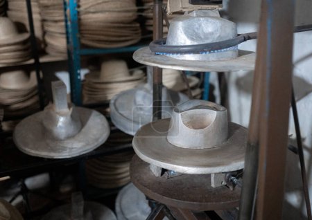 Una máquina bloqueadora de sombreros calentándose en un taller
