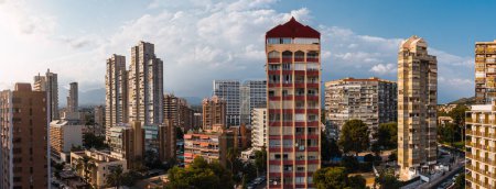 Téléchargez les photos : Vue panoramique sur drone des immeubles d'appartements modernes situés contre un ciel bleu nuageux par une journée ensoleillée en ville - en image libre de droit