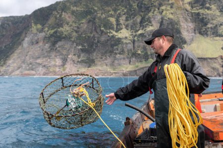 Fischer sammelt Hummernetze, die auf einem Boot stehen