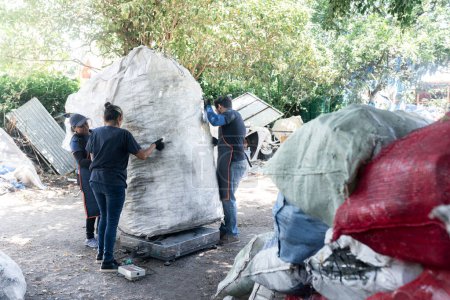 Destacando a los trabajadores hispanos que pesan plástico reciclado en una planta, con el objetivo de enfatizar su papel crucial en las prácticas de reciclaje sostenible