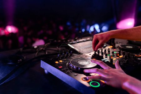 Nahaufnahme mit Kopierraum-Foto der Hände eines DJ-Mischpults in einer Disco voller Menschen