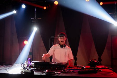 Frontansicht mit Kopierraum eines jungen Mannes DJ in den Kopfhörern spielt Musik in der Disco
