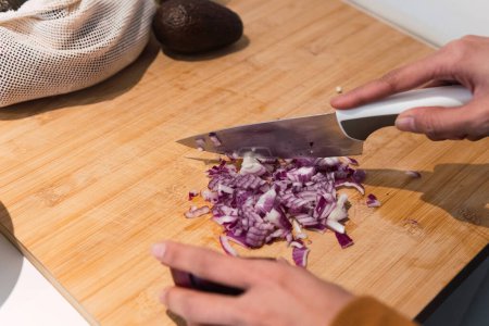 Téléchargez les photos : De la récolte ci-dessus coupe anonyme femelle avec oignon couteau dans la cuisine pendant le processus de cuisson - en image libre de droit