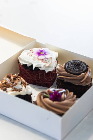 Photo for From above of various delicious vegan cakes placed in paper box on table in bakery - Royalty Free Image