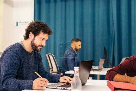 Gruppe multiethnischer Menschen, die mit Laptop in einem Coworking-Center arbeiten
