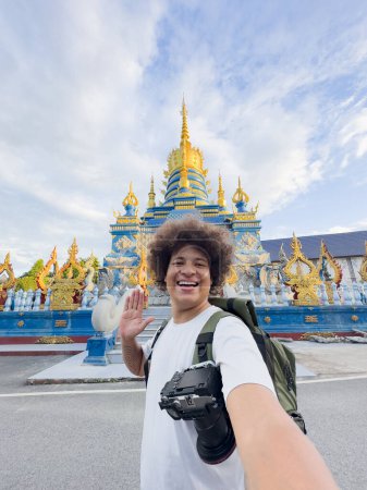 Strahlender Reisender macht Smartphone-Selfie mit farbenfrohem Tempel