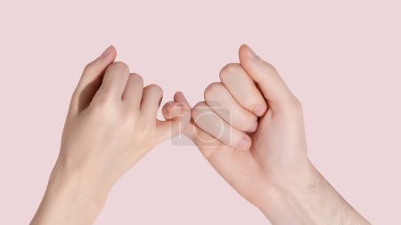 Foto de Man and woman hold each other with little fingers. ?oncept of friendly relations. High quality photo - Imagen libre de derechos