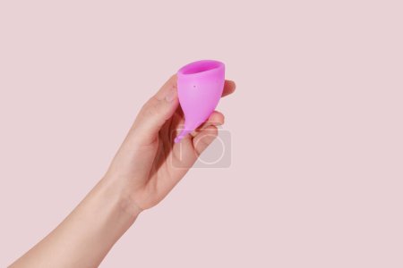 Photo for Female hand with reusable menstrual cup on pink background - Royalty Free Image