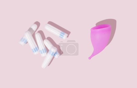Photo for Pink reusable silicone menstrual cup and tampons on pink background. Top view. Concept of feminine hygiene, gynecology and health - Royalty Free Image