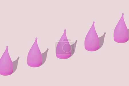 Photo for Pink reusable silicone menstrual cups on pink background. Concept of feminine hygiene, gynecology and health. Pattern - Royalty Free Image