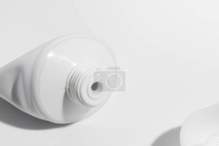Tube vide usagé avec capuchon blanc ouvert, gabarit pour dentifrice, crème, gel ou shampooing, emballage vierge sur fond blanc