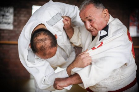 Photo for Close-up portrait of judo sensei master instructor in traditional gi kimono demonstrate judo technique - Royalty Free Image