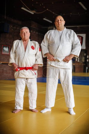 Photo for Two respected and experienced judo sensei master instructor in traditional gi kimono. A skilled martial artist demonstrates his expertiset - Royalty Free Image