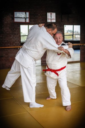 Photo for Judo sensei master instructor in traditional gi kimono demonstrate judo throw technique on tatami - Royalty Free Image
