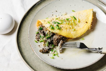 Omelet with morel mushrooms and cheese in a creamy sauce.