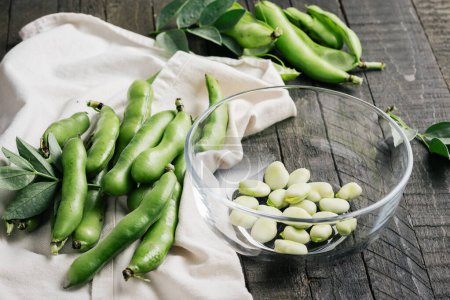 Photo for Bowl of green fava beans on a wooden table. - Royalty Free Image