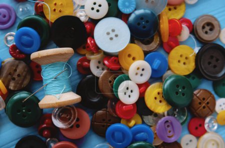 Photo for A bunch of colored buttons and a spool of thread and a needle - Royalty Free Image