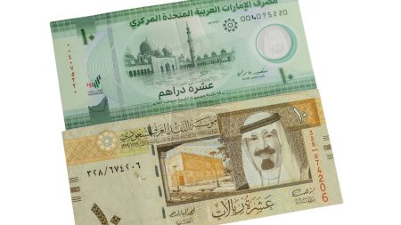 Foto de Emiratos Árabes Unidos y KSA nuevos billetes de banco de 10 dirham y riyal aislados sobre fondo blanco - Imagen libre de derechos