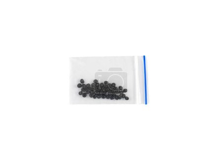 Asparagus seeds in transparent plastic pack on white background
