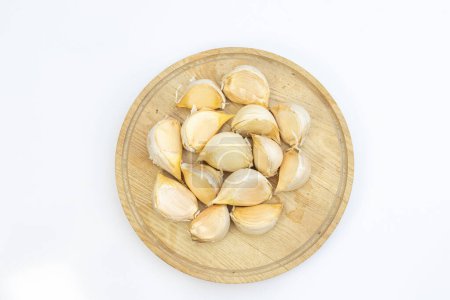 Photo for Garlic cloves on a wooden cutting board on white background with copy space - Royalty Free Image