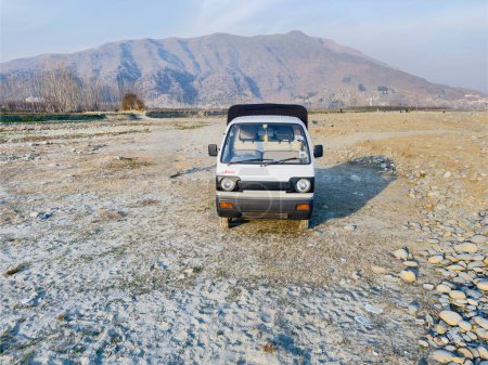 Foto de El suzuki blanco lleva un vehículo con tracción en las cuatro ruedas: Swat, Pakistán - 16 de febrero de 2024. - Imagen libre de derechos