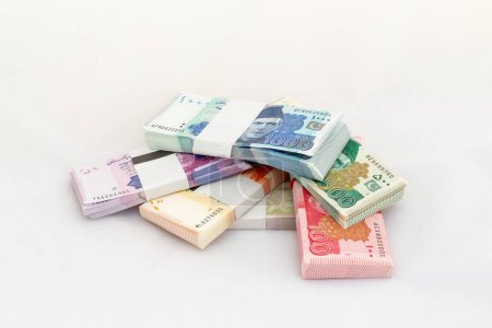 Montón de paquetes de monedas paquistaníes sobre fondo blanco aislado