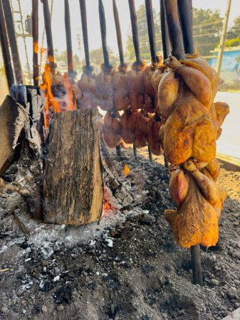Balochi chicken sajji cooking over open fire in Pakistan