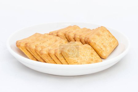 Salzige Cracker in einem Teller isoliert auf weißem Hintergrund.