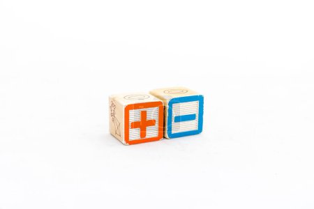 Symboles mathématiques plus et moins blocs de bois isolés sur fond blanc. Concept de mathématiques.