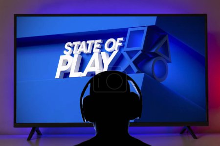 Téléchargez les photos : Man with headphone watching  Playstation State of Play logo at TV screen, 23 Fev, 2023, Sao Paulo, Brazil - en image libre de droit